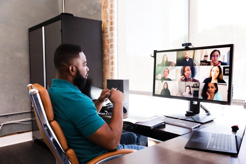 A man video conferencing with his team during remote work.